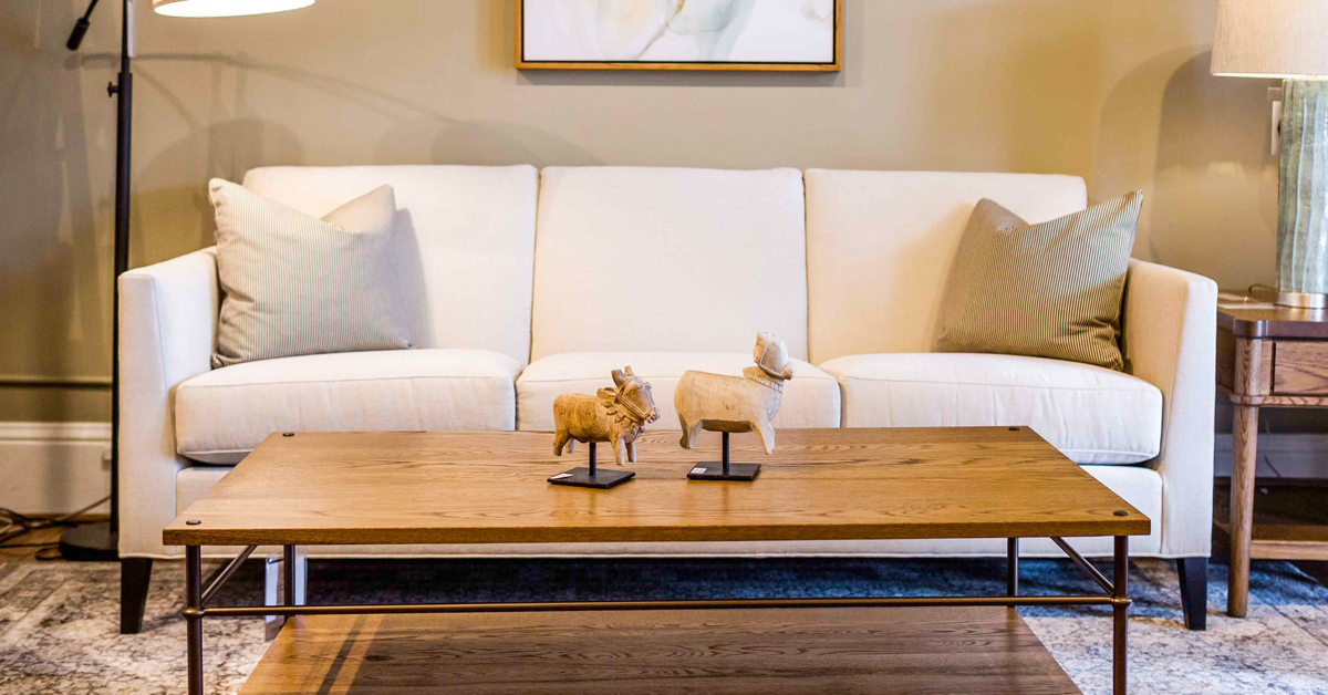 A white couch with a brown coffee table