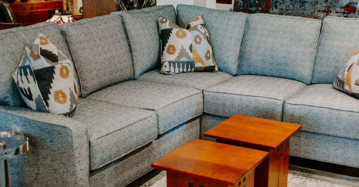 A blueish gray section couch with an orangish coffee table