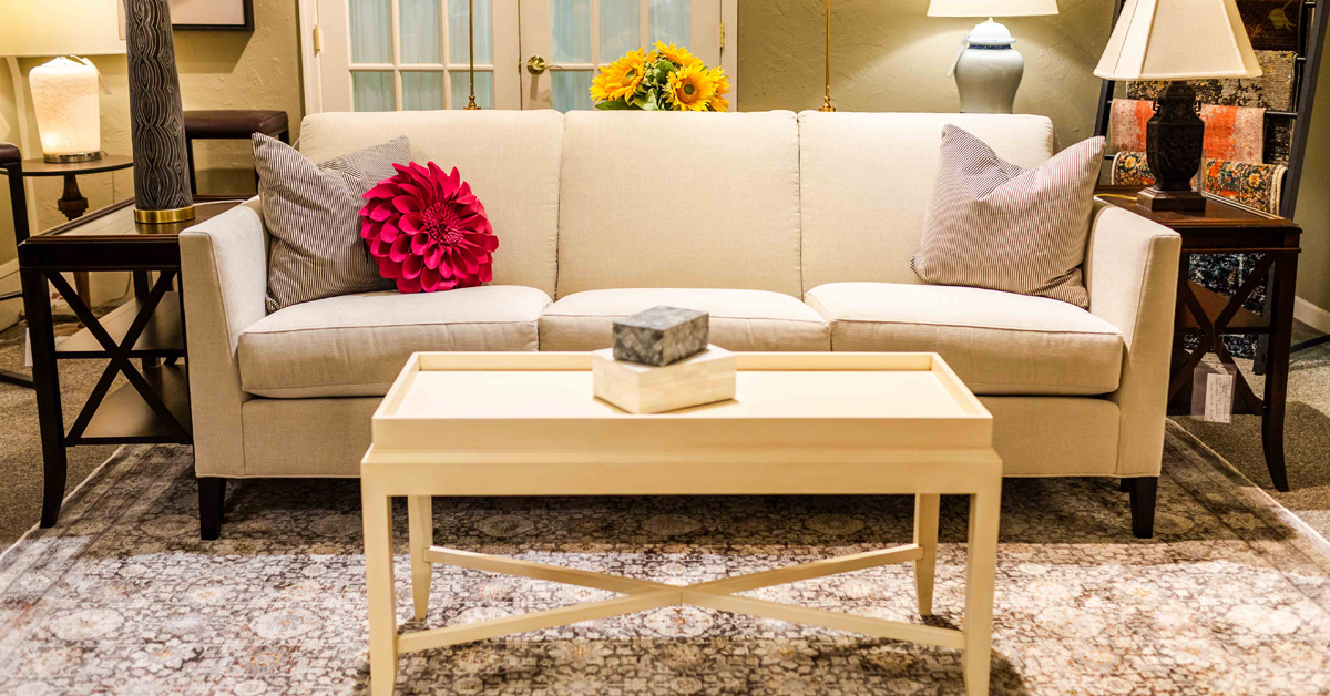 White couch with 3 pillows and a light colored coffee table