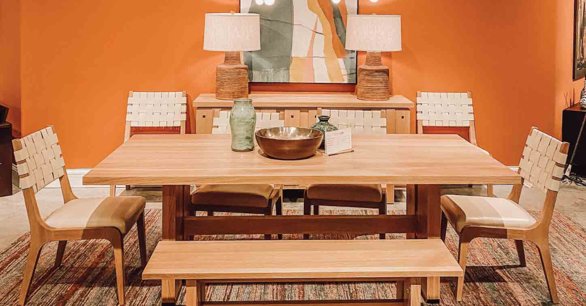 A dining room set in front of an orange wall