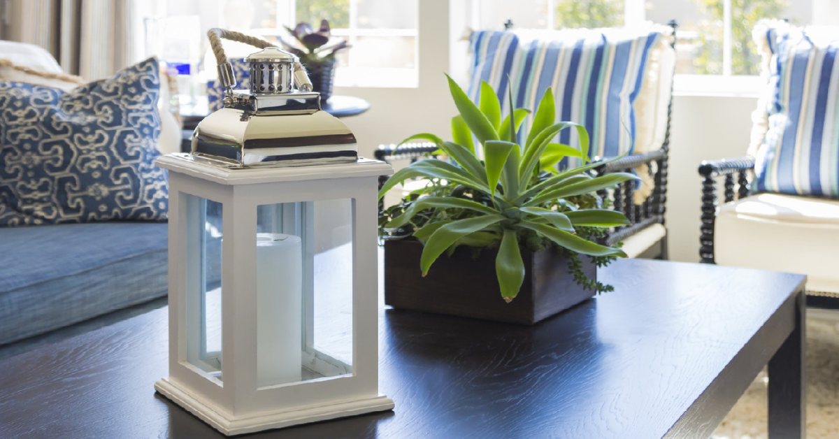 A coffee table with some decorations on top and two chairs and a couch in the background