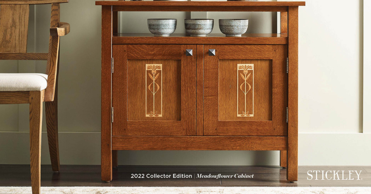 A wooden stand storage container with two doors and bowls on top of it