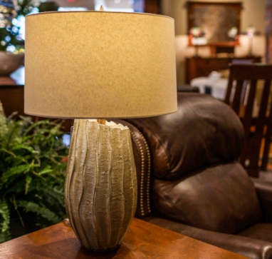 A lamp with  a brown recliner and a dinning set visible in the background