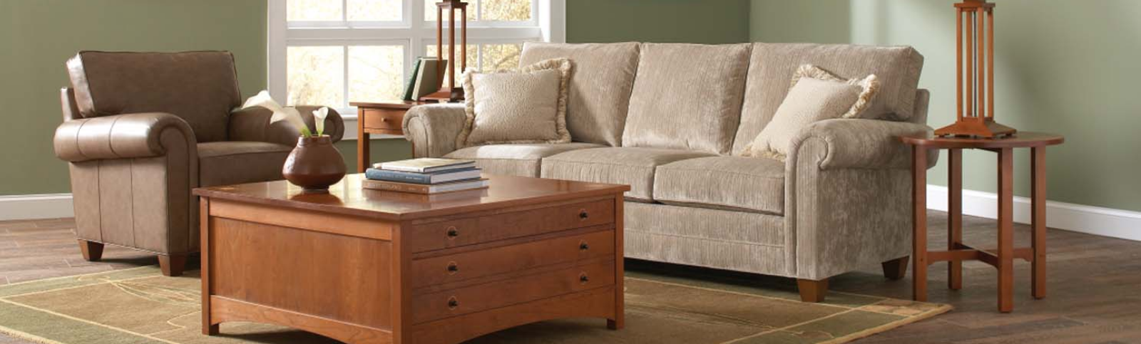 A beige colored couch, a brown chair, and wooden coffee tables and end tables with accessories on top of them