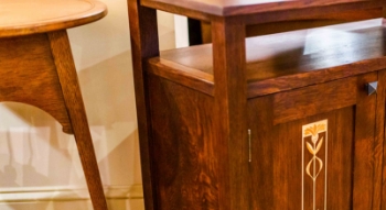 A wooden dresser with two door handles 