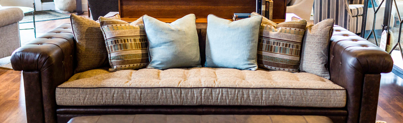 A brown couch with multicolored pillows on top of it