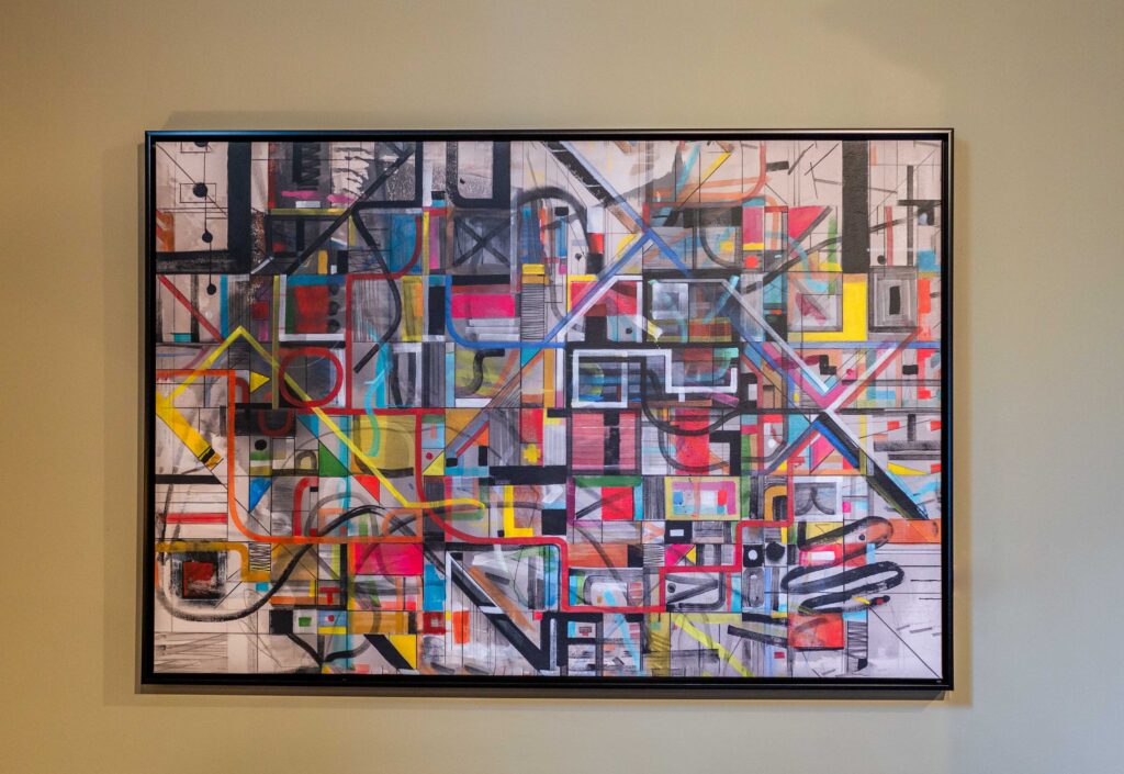 A busy piece of wall art with dozens of overlapping colors and designs